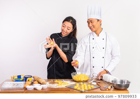 male and female chefs making round cake dough by hand male and female chefs making round cake dough by hand 97809933