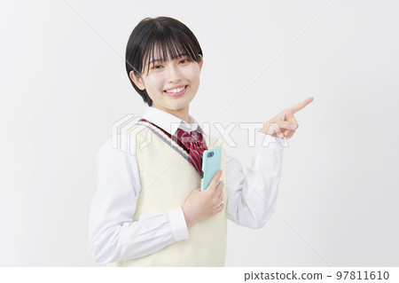 一個拿著智能手機並指向正確的白色背景的高中女生 97811610