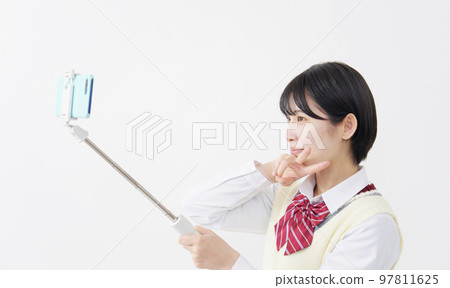 High school girl taking a selfie with a smartphone white background High school girl taking a selfie with a smartphone white background 97811625