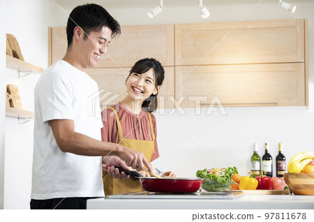 young couple cooking 97811678