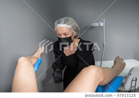 The doctor examines the patient on the gynecological chair. 97813128