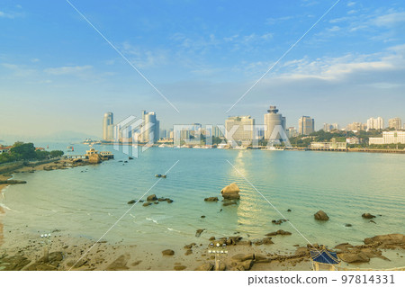 The blue sea and the buildings of Xiamen Island as seen from Gulangyu Island, Xiamen, Fujian Province / Xiamen, China The blue sea and the buildings of Xiamen Island as seen from Gulangyu Island, Xiamen, Fujian Province / Xiamen, China 97814331