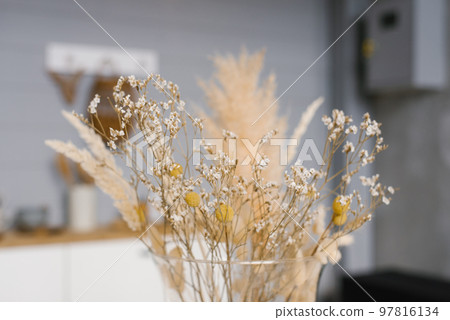Dried flowers in a yellow vase close-up. Cozy home decor 97816134