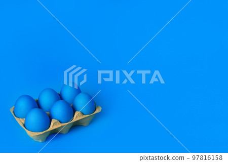 Six blue painted Easter eggs in yellow wrapping on blue background. Happy Easter holiday card or banner. Copy space. Creative Easter Six blue painted Easter eggs in yellow wrapping on blue background. Happy Easter holiday card or banner. Copy space. Creative Easter 97816158