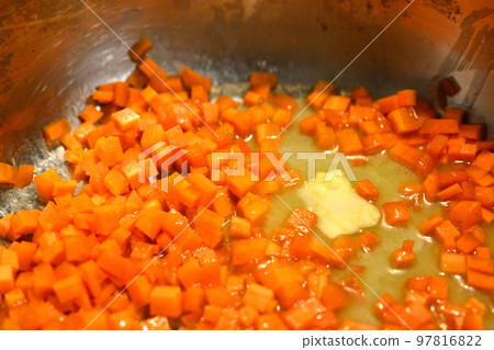 Fry carrots in butter using a deep stainless steel pan Fry carrots in butter using a deep stainless steel pan 97816822