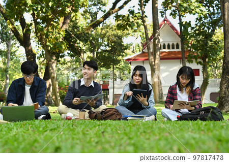 Group of students doing group project and reading book together in university campus. Education and youth lifestyle concept Group of students doing group project and reading book together in university campus. Education and youth lifestyle concept 97817478