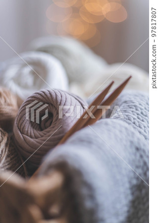 Cozy homely atmosphere. Female hobby knitting. Yarn in neutral shades in a basket 97817807
