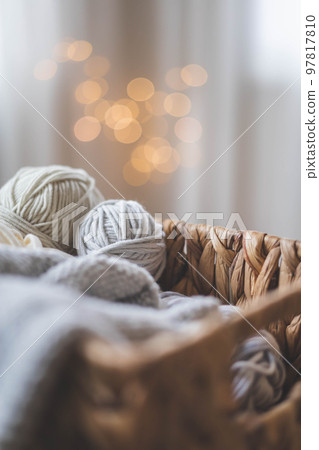 Cozy homely atmosphere. Female hobby knitting. Yarn in grey colors in a basket Cozy homely atmosphere. Female hobby knitting. Yarn in grey colors in a basket 97817810