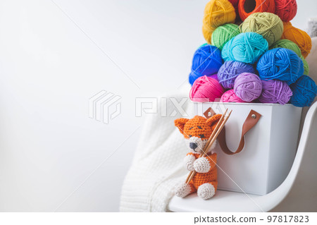 Lots of bright, colorful yarns for knitting and crochet in a stylish scandi style basket.  97817823