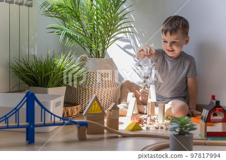 Preschool baby boy playing wooden Montessori materials rainbow arch railways at childish room 97817994