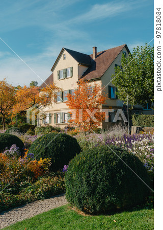 House with nice garden in fall. Flowers in the City Park of Bietigheim-Bissingen, Baden-Wuerttemberg, Germany, Europe. Autumn Park and house, nobody, bush and grenery House with nice garden in fall. Flowers in the City Park of Bietigheim-Bissingen, Baden-Wuerttemberg, Germany, Europe. Autumn Park and house, nobody, bush and grenery 97818084