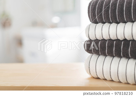 Bath fresh towels pile soft textile cotton body care neatly folded white gray laundry flower shelf. Blurred background Bath fresh towels pile soft textile cotton body care neatly folded white gray laundry flower shelf. Blurred background 97818210