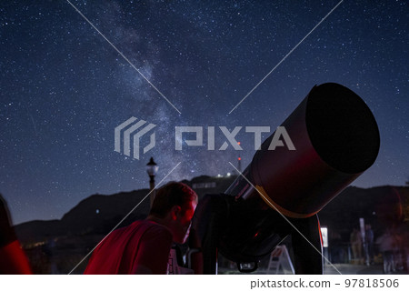 Los Angeles, USA. September 20, 2022. Man looking through telescope at Griffith Observatory by mount Hollywood with scienic view of stars in sky during nighttime 97818506