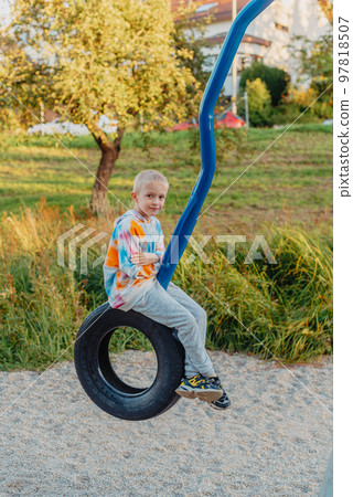 Funny cute happy baby playing on the playground. The emotion of happiness, fun, joy. Smile of a child. boy playing on the playground Funny cute happy baby playing on the playground. The emotion of happiness, fun, joy. Smile of a child. boy playing on the playground 97818507