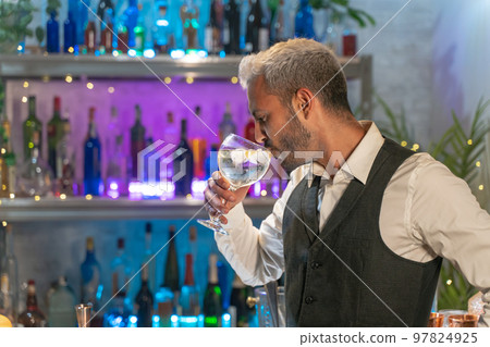 Professional barman tasting cocktail in nightclub. Night life concept 97824925
