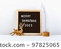 Merry Christmas lettering on letter board. Eco tree and golden deer. minimalistic new year background 2023 97825065
