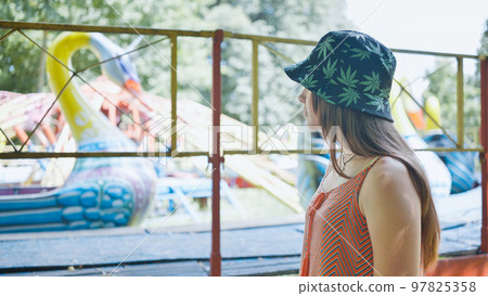 A girl looks at a working ride in a children's park. 97825358
