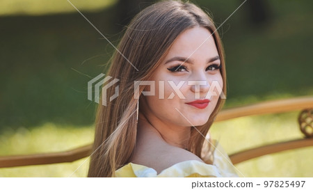 A young girl poses in a park in the summer. Close-up of her face. A young girl poses in a park in the summer. Close-up of her face. 97825497