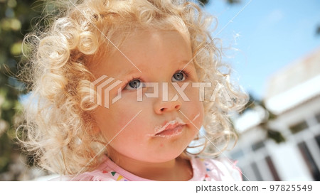 Portrait of a funny girl with leftover cream from a cake. Portrait of a funny girl with leftover cream from a cake. 97825549