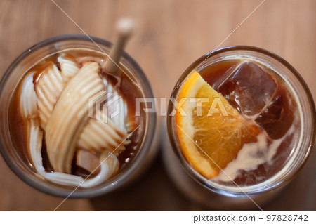 Glass of americano mixed with coconut and orange juice Glass of americano mixed with coconut and orange juice 97828742