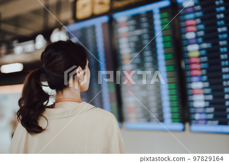 Young asian woman with passport and boarding pass as a hand in international airport Young asian woman with passport and boarding pass as a hand in international airport 97829164