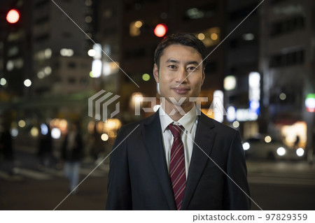 穿著西裝的商人夜街角看著相機肖像 97829359
