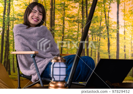 工作 一名年輕女子坐在戶外椅子上,操作筆記本電腦 工作 一名年輕女子坐在戶外椅子上,操作筆記本電腦 97829452