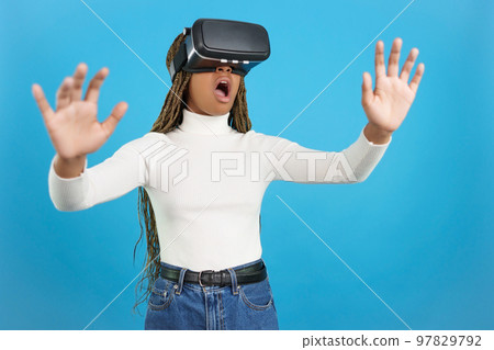 Shocked african woman wearing virtual reality goggles 97829792