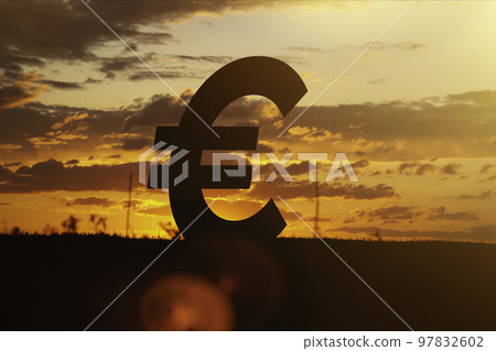 Euro money sign at sunset in the rays of the setting sun. Sunset currency. Devaluation of money. Euro money sign at sunset in the rays of the setting sun. Sunset currency. Devaluation of money. 97832602