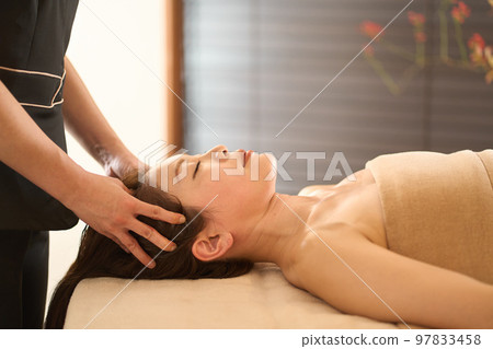 Woman receiving head massage at beauty salon Woman receiving head massage at beauty salon 97833458