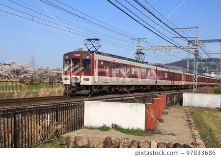 A train on the Kintetsu Nara Line runs past cherry blossom trees in the Nara Heijo Palace Ruins, a World Heritage site. 97833686