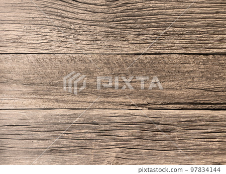 木板牆表面的背景圖像，上面覆蓋著已經風化並具有深鑿紋理的陳年灰褐色木材 97834144