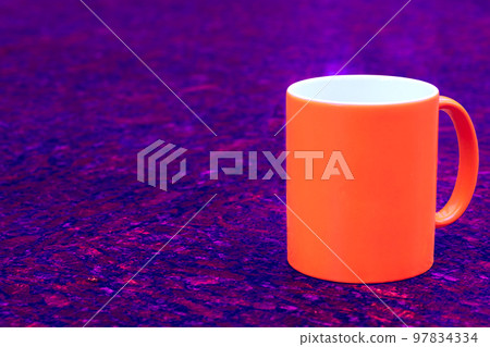 Red ceramic cup mug on dark red blue spotted background Red ceramic cup mug on dark red blue spotted background 97834334