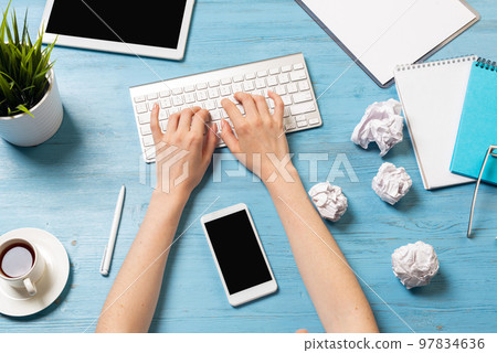 Freelancer sitting at desk and typing on keyboard Freelancer sitting at desk and typing on keyboard 97834636