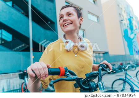 Smiling girl with headphones drives a bicycle 97834954
