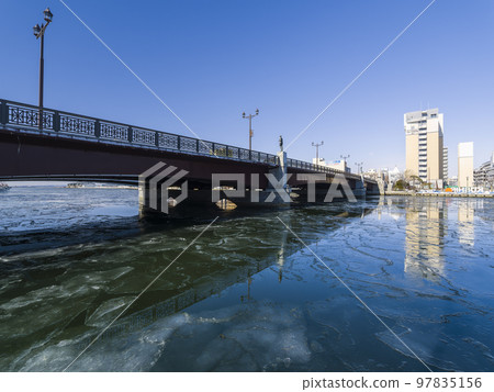 Kushiro River and Nusamai Bridge in winter covered with thin ice / Kushiro, Japan 97835156