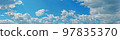 Blue sky with fluffy clouds wide background 97835370