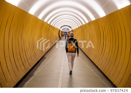 Woman walks through pedestrian Brunkenberg Tunnel in Stockholm, Sweden 97837424