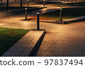 Row Of Outdoor Landscape Hard Paving Light. Lighting element on the green lawn along the footpath. Modern lighting system in landscape design. 97837494
