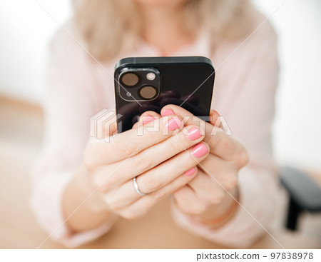 Front view of woman hand using mobile phone, work and communication concept, home office Front view of woman hand using mobile phone, work and communication concept, home office 97838978