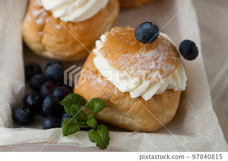 Swedish Semla or Shrove bun with light wheat bread and almond paste and whipped cream filling, mint 97840815