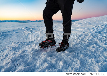Mountain Boot with crampons on while hiking in the mountains in winter. 97841112