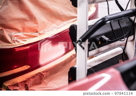 Ir curing the basecoat on the bumper of a red car Ir curing the basecoat on the bumper of a red car 97841114