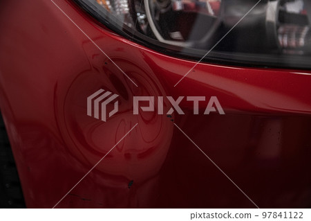 Dent on the bumper of a red car for repair 97841122