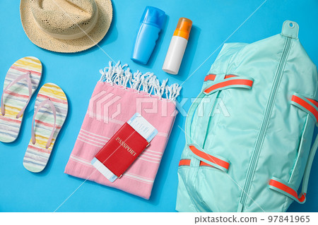 Flat lay composition with bag and travel accessories on blue background 97841965