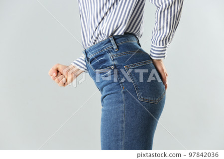 Woman suffering from hemorrhoid on light grey background, closeup 97842036