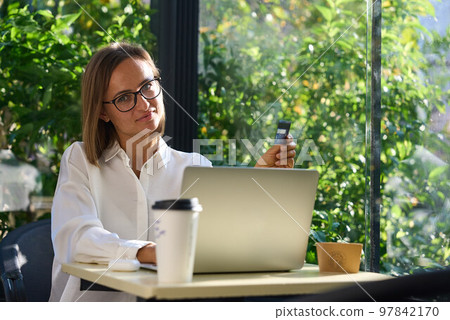 Young woman holding credit card and using laptop computer. Businesswoman working at home. Online Young woman holding credit card and using laptop computer. Businesswoman working at home. Online 97842170