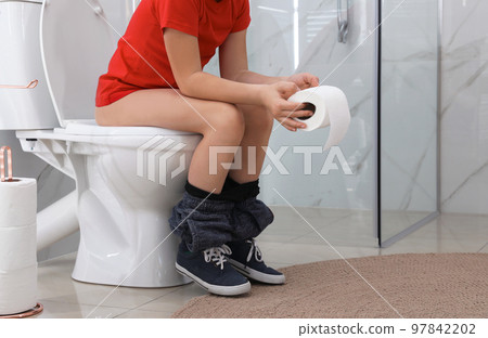 Boy with paper suffering from hemorrhoid on toilet bowl in rest room, closeup Boy with paper suffering from hemorrhoid on toilet bowl in rest room, closeup 97842202