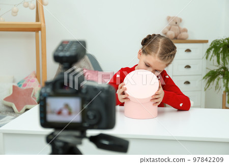 Cute little blogger with box recording video at home Cute little blogger with box recording video at home 97842209