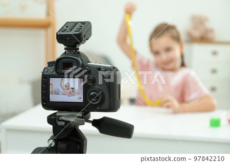 Cute little blogger with slime recording video at home, focus on camera Cute little blogger with slime recording video at home, focus on camera 97842210